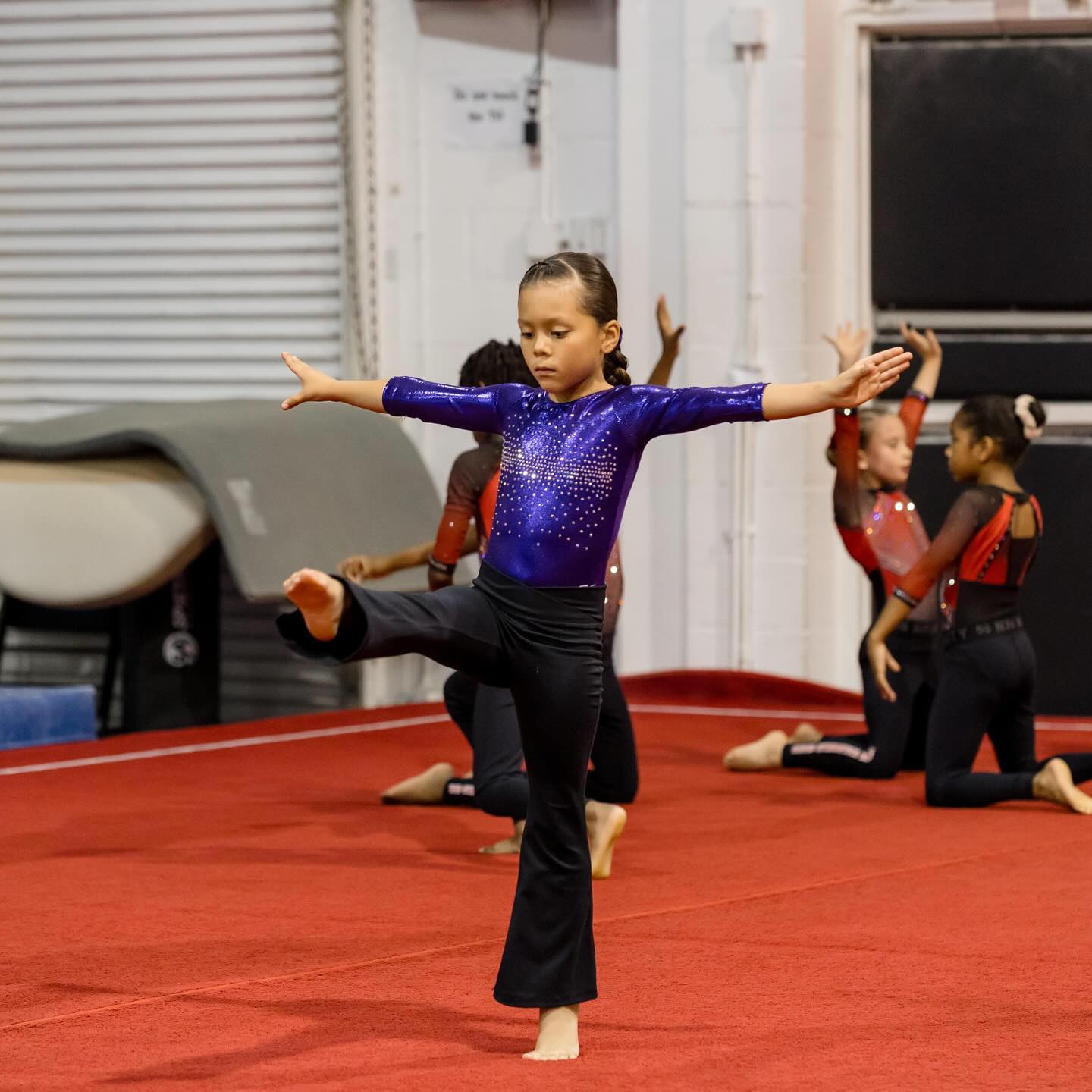 niña haciendo balance en el piso de gimnasia